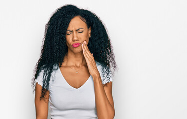 Middle age african american woman wearing casual white t shirt touching mouth with hand with painful expression because of toothache or dental illness on teeth. dentist