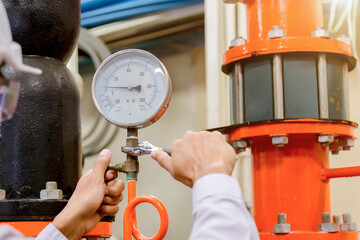 Engineer checking Condenser Water pump and pressure gauge , chiller water pump with pressure...