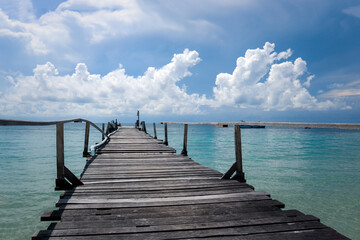 Koh Samed Island view,  beautiful natural scene of tropical summer sea, wooden bridge leading over crystal clear water sea and cloudy blue sky.