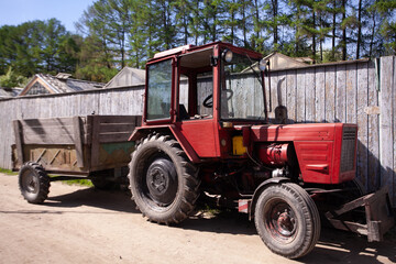 Obraz premium photo of old vintage red tractor. Vintage tractor by barn