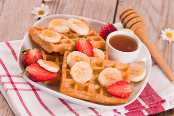 Waffles with strawberries, bananas and honey.