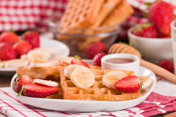 Waffles with strawberries, bananas and honey.