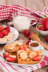 Waffles with strawberries, bananas and honey.
