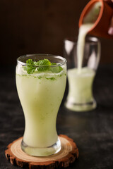 Pouring serving Spiced buttermilk , chaas , chaach , moru , sambharam , curd, lassi , yogurt, cool refreshing drink for hot summer in glass , Kerala, India Sri Lanka. Flavored Indian buttermilk.