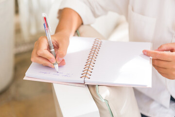 Businesswoman makes a note in notebook. Pen in hand