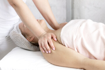 Massage the body, arms, legs, back, abdomen in the massage room with the hands of a specialist with oil with a copy of the space.  The concept of professional body care.
