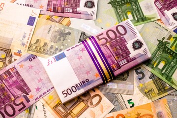 A pack of European currency lies on the background of the Euro
