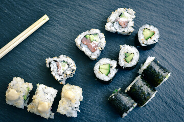 Japanese sushi food. Maki ands rolls with tuna, salmon, shrimp.Assorted sushi. Rainbow roll, uramaki, hosomaki and nigiri.  Sushi Set sashimi  served on stone slate