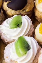 Assortment of mini cakes with cream, chocolate and assorted fruits