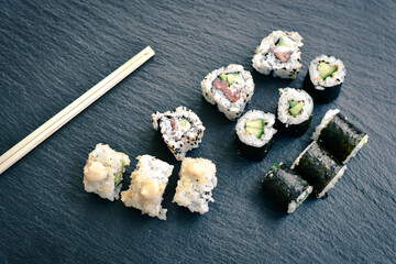 Japanese sushi food. Maki ands rolls with tuna, salmon, shrimp.Assorted sushi. Rainbow roll, uramaki, hosomaki and nigiri.  Sushi Set sashimi  served on stone slate