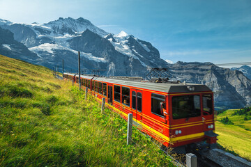 Electric tourist cogwheel train on the slope in Switzerland - 433894322