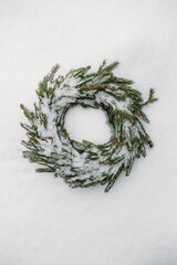 snow covered christmas wreath made of natural fir branches