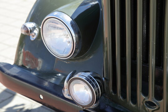 Vintage soviet military off road car headlight lamps, front bumper and radiator grille closeup