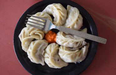 Vegetable momos served in a black plate
