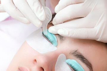 Young woman doing eyelash lamination procedure - obrazy, fototapety, plakaty