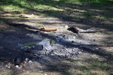 Abandoned extinguished fire place white bricks ring on ground close up with sun shadows, outdoors picnic leisure, empty campsite fireplace safety on a spring day, picture with copy space
