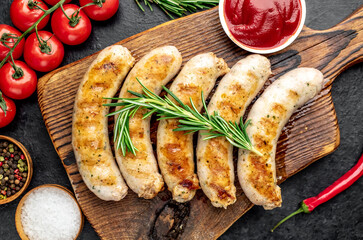 grilled sausages with spices on a stone background