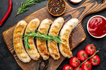 grilled sausages with spices on a stone background