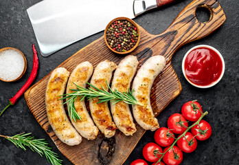 grilled sausages with spices on a stone background