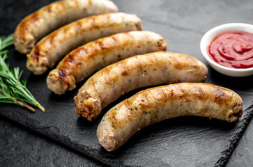 grilled sausages with spices on a stone background