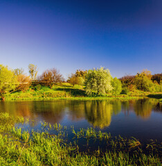 Panorama of river under the hills in spring
