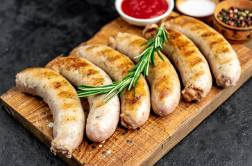 grilled sausages with spices on a stone background