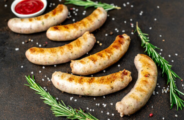 grilled sausages with spices on a stone background
