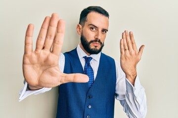 Young man with beard wearing engagement ring with open hand doing stop sign with serious and confident expression, defense gesture