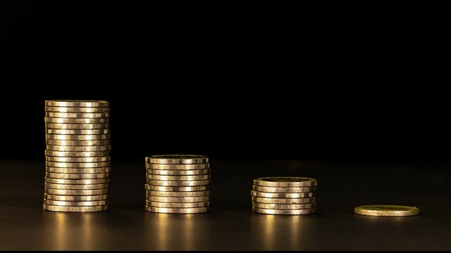 4K Stop motion shows the stack of four piles of gold cash coins decreasing and increase fading disappear from below with Key frame technique at black background, business and financial trading 
concep
