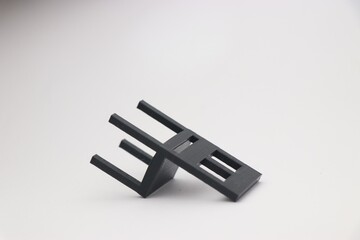 Close up of small chair which is black made using 3D printing technology
