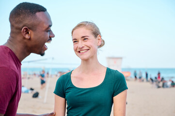 young multiethnic couple at the beach smiling