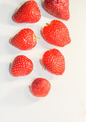 A lot of red ripe tasty strawberries lie on a white background