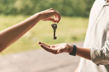 Close up of female real estate agent giving keys to man 