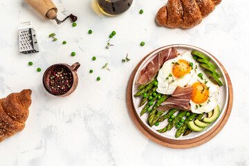 Ketogenic diet healthy breakfast asparagus with prosciutto, avocado and fried eggs. Healthy food, diet lunch concept. Keto Paleo diet menu, top view