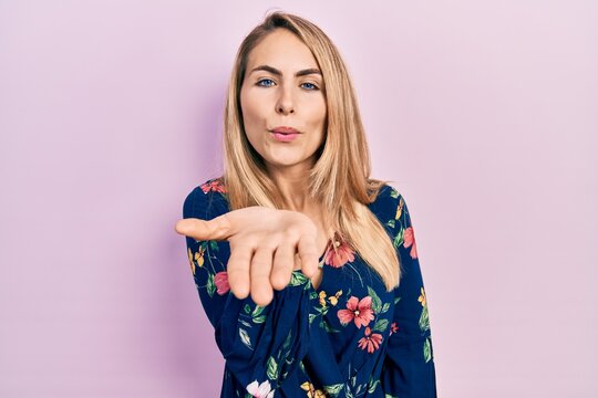 Young caucasian woman wearing casual clothes looking at the camera blowing a kiss with hand on air being lovely and sexy. love expression.