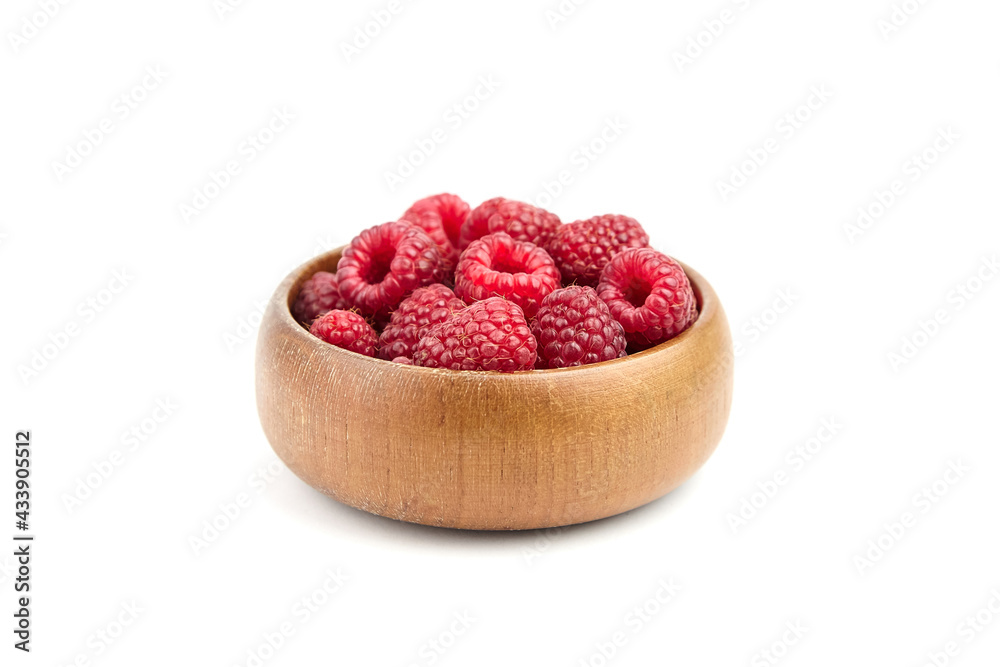 Wall mural fresh raspberries in wooden bowl isolated on white background. red sweet raspberries