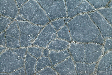 Detail of cracked asphalt pavement surface. Chapped footpath texture. Pavement deffects, overhead shot. Large cracks on asphalt footway. Cracky blue walkway. Crannied way, closeup shot. Rimous walk