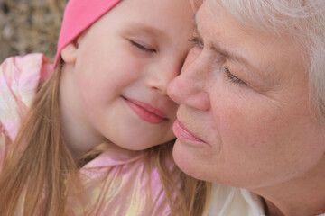 Close up portrait of grandmother and granddaughter . Having good times with grandparent outdoors