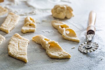 Cutting homemade angel wings from fresh dough. Homemade pastries.