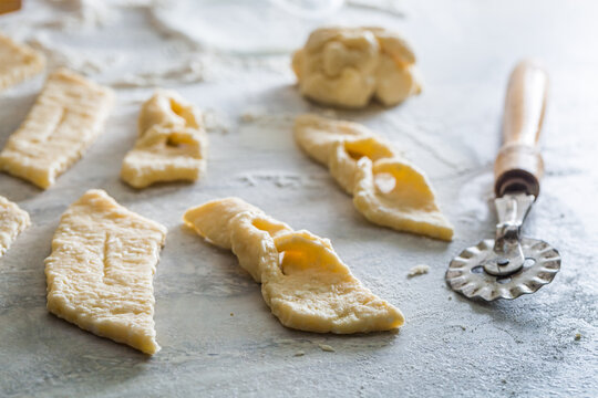 Cutting homemade angel wings from fresh dough. Homemade pastries.