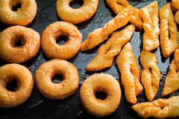 Golden donuts on black tray. Homemade pastries for Fat Thursday.