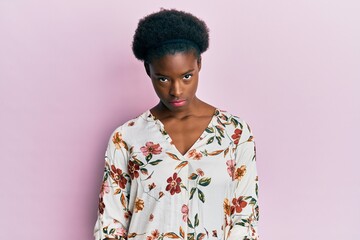 Young african american girl wearing casual clothes skeptic and nervous, frowning upset because of...