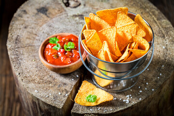 Mexican popular snack. Nachos with red pepper dip and salt.