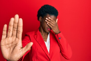 Young african american girl wearing business clothes covering eyes with hands and doing stop gesture with sad and fear expression. embarrassed and negative concept.