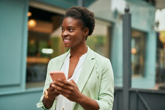 Young african american businesswoman smiling happy using smartphone at the city.