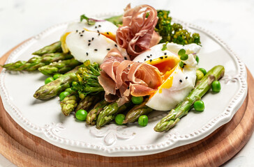 Tasty asparagus, poached egg and jamon, ham, prosciutto. Healthy food. diet lunch concept. Keto Paleo diet menu
