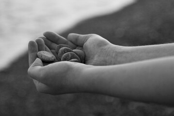 hands  with stone on the beach