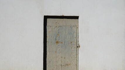 humble metal door on white facade wall