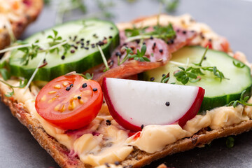 Sandwiches with cream cheese, vegetables and salami.