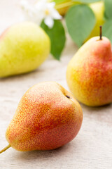 Fresh pears with leaves in a on wooden background.